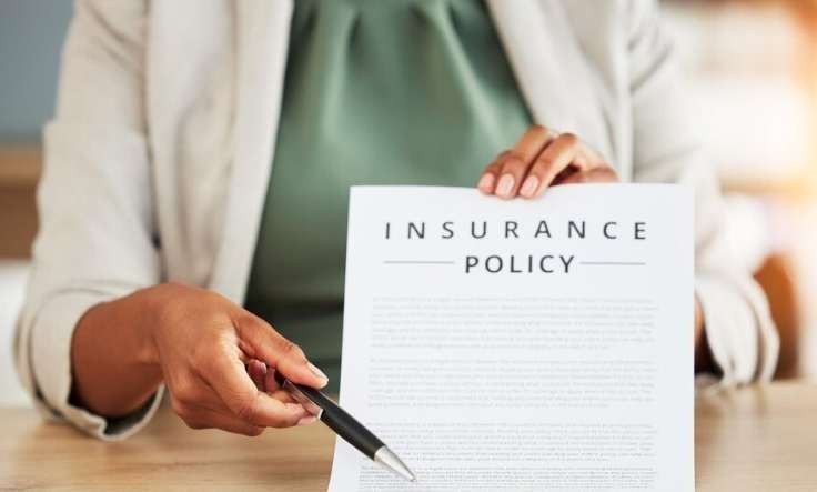 Parent and therapist discussing ABA therapy insurance coverage documents, highlighting policy details for autism care.